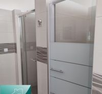 Bathroom in production premises with ceramic tiles and a shower enclosure.