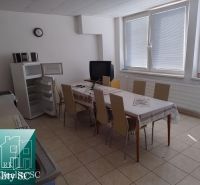 Canteen in the production area with a refrigerator, television, and a table for eight people.