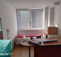 A room in a production area with a bed, table, and floor with a wooden decor.