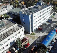 Buildings and warehouses on Staviteľská Street in Bratislava III with a large number of vehicles and goods.