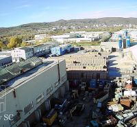 A view of warehouses and halls on Staviteľská Street in Bratislava III surrounded by trucks and materials.