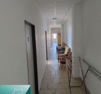 A corridor with chairs in the premises of warehouses and halls, with access to rooms.