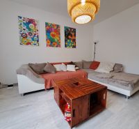 Living room with a sofa and a table made from crates, floor with wood decor, 3-room apartment.