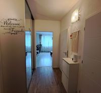 Interior of a 3-room apartment with a wooden decor floor and light furniture.