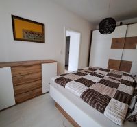 Bedroom in a 3-room apartment with a dresser and a wardrobe, wooden decor flooring.