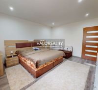 A bedroom in a family house with a wooden decor floor and a comfortable bed.