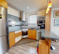 A kitchen in a family house with wood decor flooring and modern equipment.
