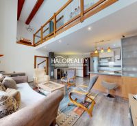 Interior of a family house with a wooden decor floor, open kitchen, and gallery.