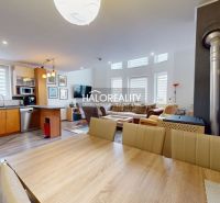 A spacious kitchen in a family house with a wood-patterned floor and modern furniture.