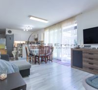 Living room in a family house with a wooden decor floor, sofa, and dining table.