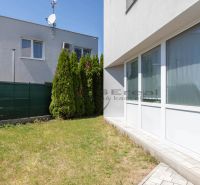 A family house in Stupava with a grassy yard and a hedge.