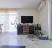 Living room in a family house with a television, a cage, and a floor with a wooden decor.
