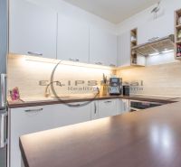 A kitchen with furniture, appliances, and wooden decor in a family house.