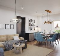 A living room of a three-room apartment with a wooden decor floor, a sofa, and a dining table.