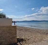 A sandy beach with pebbles and a view of the sea near Sukošan.