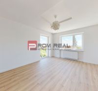 Bright empty interior with wood-decor flooring, large windows, and white walls in a family house.