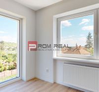 A room with large windows, a view, and a wooden decor floor in a family house.