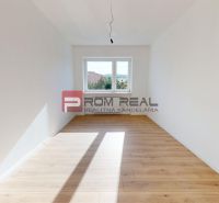 A bright room with white walls and wood-decorated floors in a family house.