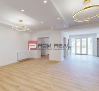 Living room in a family house with large windows and a wooden decor floor.