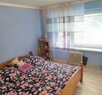 A bedroom in a 3-room apartment with floral bed linen and a wooden decor floor.