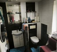 A bathroom in a 3-room apartment with black and white tiles, a washing machine, and a window.