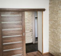 Interior of a 3-room apartment with sliding doors and decorative stone cladding.
