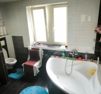 Bathroom with a bathtub and toilet in a 3-room apartment, tiles on the walls.