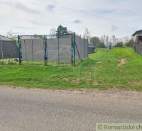 Gardens in Hruboňovo with an access road and fencing.
