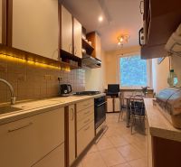 A kitchen in a 3-room apartment with LED lighting and a dining area.