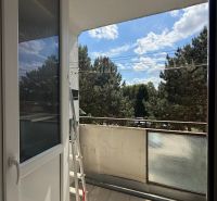 The balcony of a 3-room apartment in Zlaté Moravce with a view of greenery and the sky.