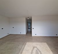 Interior of a holiday apartment with large white walls and a wooden decor floor.
