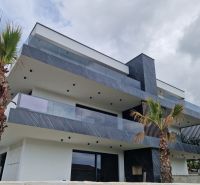 A recreational apartment in Stara Novalja with geometric architecture and palm trees against the backdrop of the sky.