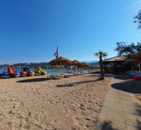 A beach with sunbeds and pedal boats in Stara Novalja near a holiday apartment.