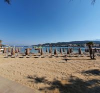 A sandy beach with umbrellas and loungers at a holiday apartment in Stara Novalja.