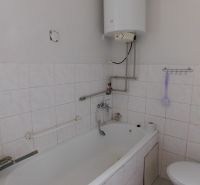 Bathroom with a bathtub, boiler, and toilet in a family house.