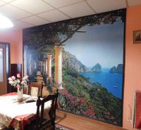 A dining room in a family house decorated with a wall mural featuring a seaside motif and wooden decor.