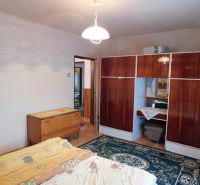 A bedroom in a family house with carpets and antique furniture.