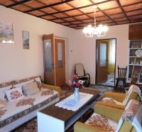 Living room in a family house with flowers and a patterned carpet.