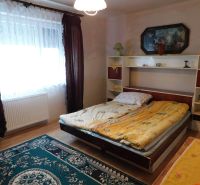 A bedroom in a family house with carpets and a wooden decor floor.