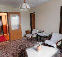 Living room in a family house with upholstered chairs and a decorative carpet.