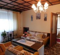 Living room with a floral sofa and wooden decor in a family house.