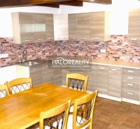 A kitchen in a family house with a wooden decor floor and brick cladding.