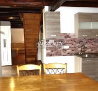 A kitchen with a wooden decor floor in a family house, wooden ceiling, brick wall cladding.
