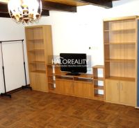 Living room with shelves, television, and wooden decor flooring in a family house.