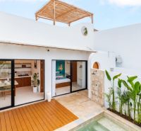 Villa in Bali with a wooden decor floor by the pool and an outdoor shower.