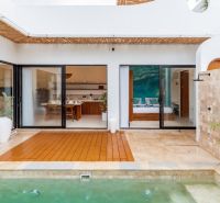 Villa in Bali with a pool, wooden decor flooring, and open design.