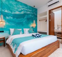 Bedroom in a villa with a turquoise wall, a comfortable bed, and atmospheric lights.