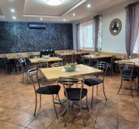 A dining area in commercial premises with tables and chairs, a floor with a wooden decor.