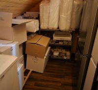 Storage space with wood-patterned flooring and various boxes in commercial premises.