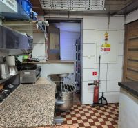 A kitchen in commercial premises with a marble countertop and tiled floor.